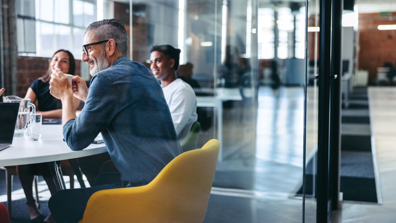 Group of people sitting around a table talking in an office