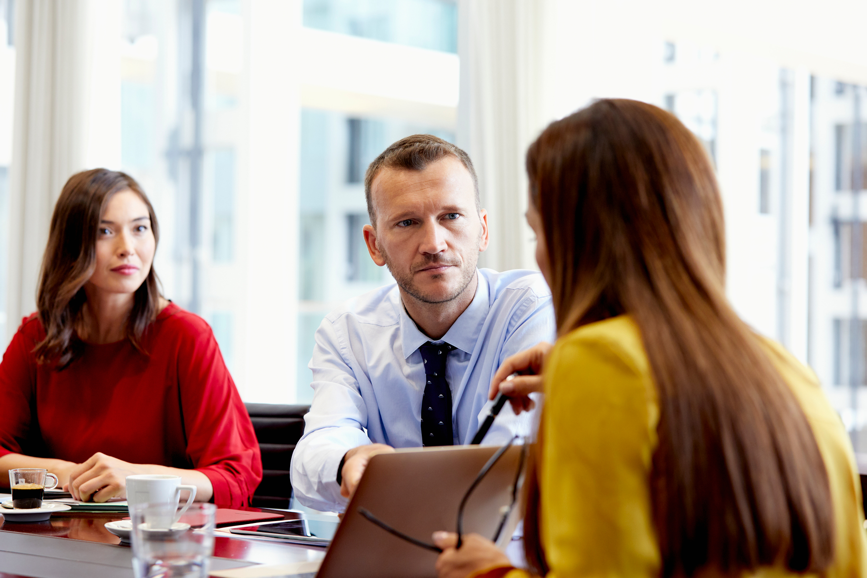Two women and a man discussing in an office environment