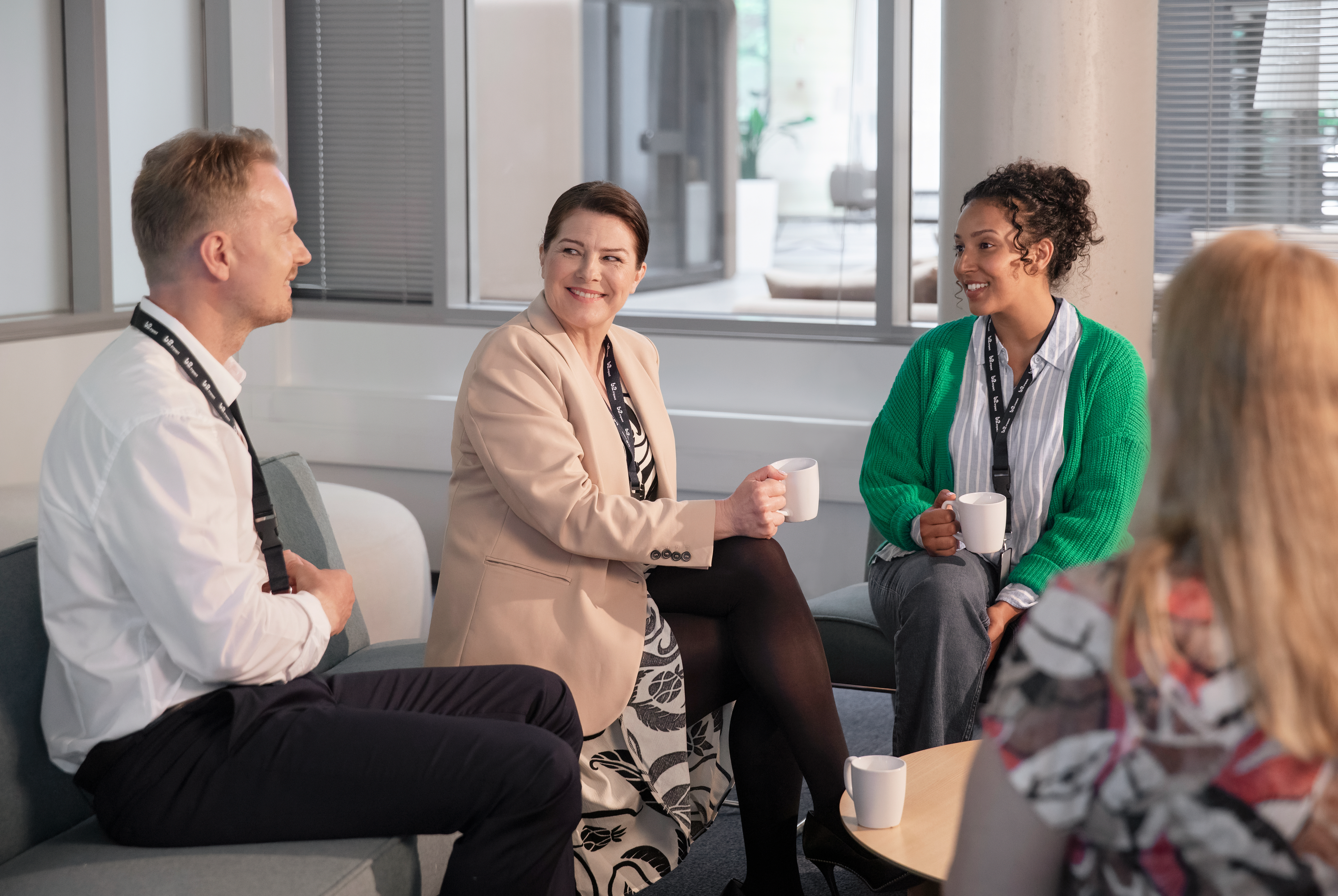 Two women and a man talking in a lounge